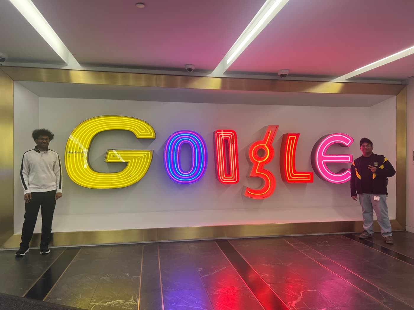 In front of the neon Google sign at Google NYC
