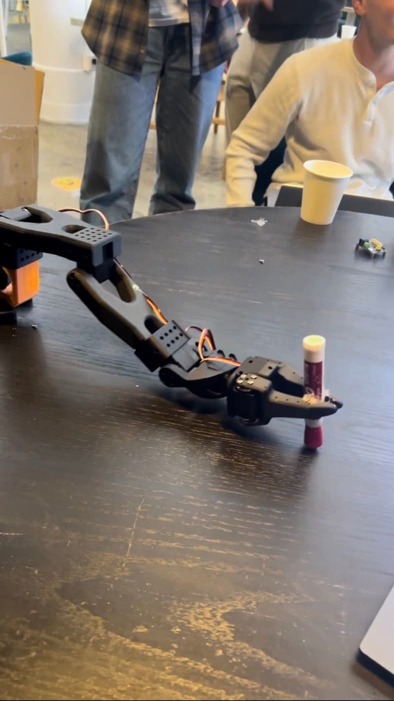 A robot arm picking up a glue stick